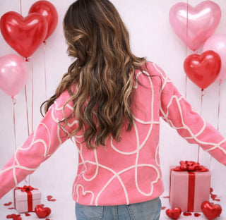 	Pink sweater with swirling heart piping detail