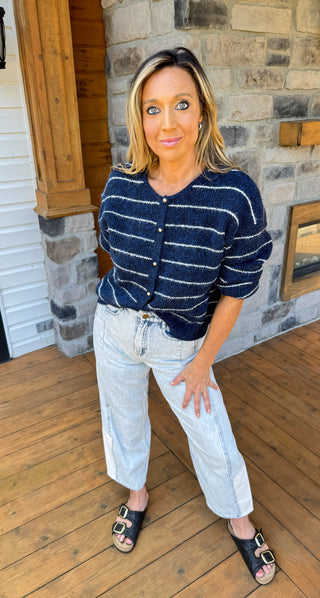 Navy blue cardigan with thin ivory stripes and gold hardware. 