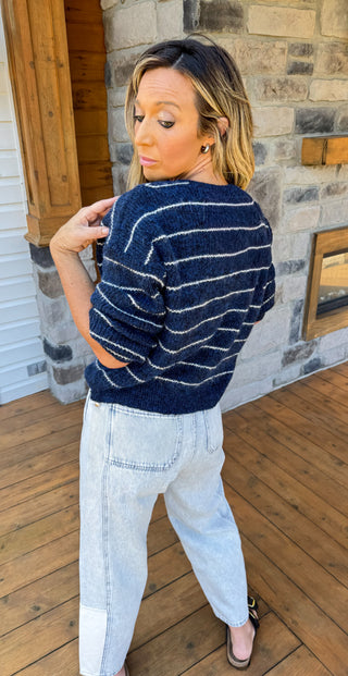 Navy blue cardigan with thin ivory stripes and gold hardware. 