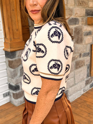 white short sleeve sweater top with navy horse pattern and metallic gold trim at neck and sleeves