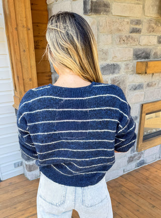 Navy blue cardigan with thin ivory stripes and gold hardware. (back view)