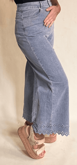 High waisted light wash denim with laser cut embroidery at pant hem 