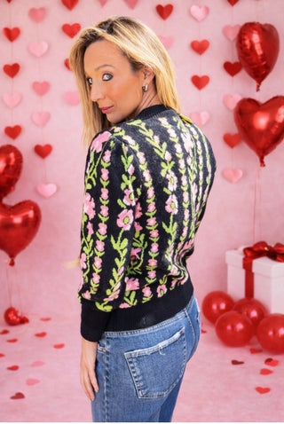 The Noir Bloom Sweater featuring pink floral vines on a black base